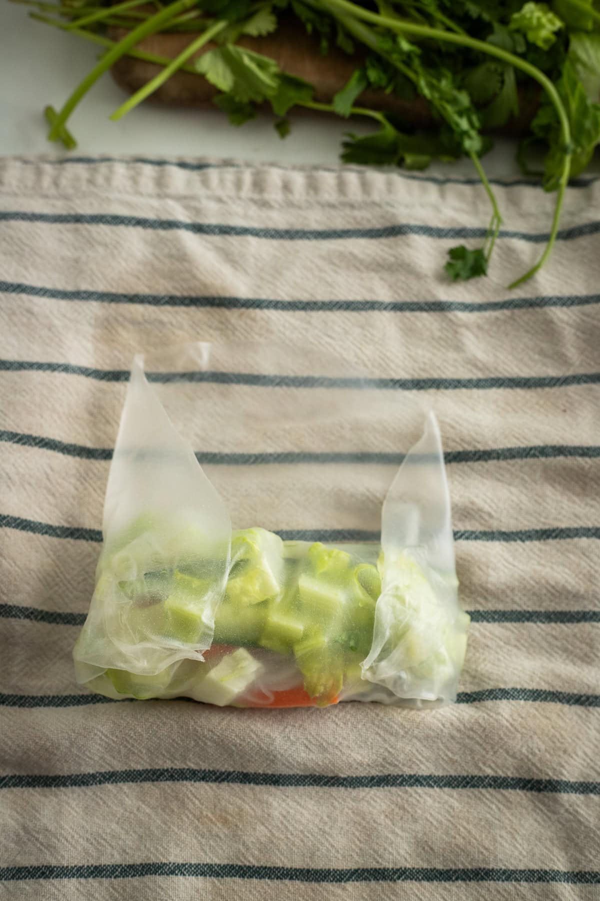 The sides of rice paper folded over chopped veggies.