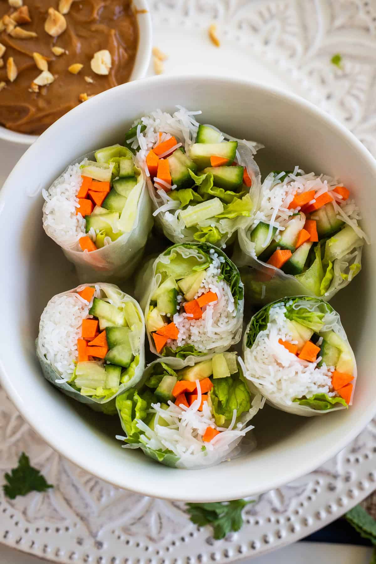 Spring rolls cut in half and placed in a white dish.